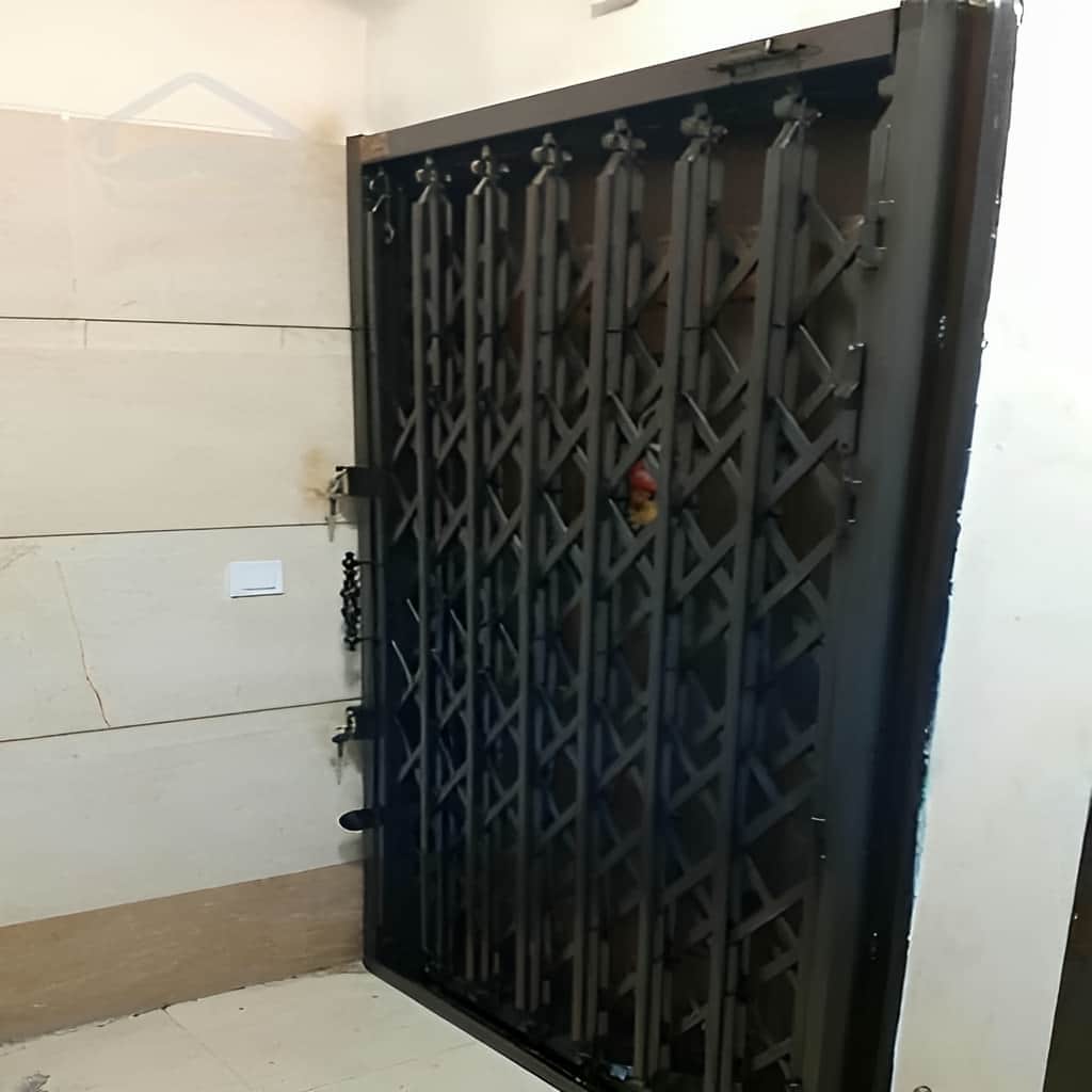 درب آکاردئونی فلزی نصب شده پشت درب ورودی آپارتمان