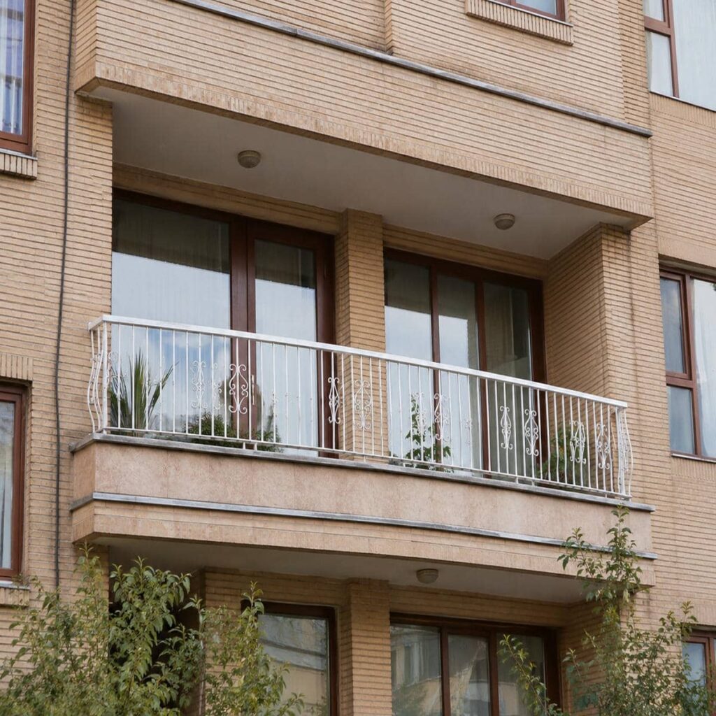نرده بالکن شیشه ای کنار نمای ساختمان